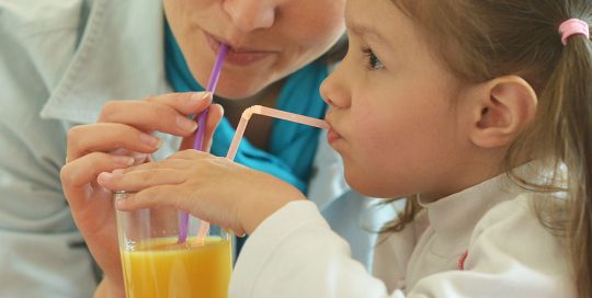 mom and daughter drinking orange juice