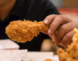 person eating fried chicken
