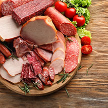 assorted cured deli meats on a wood platter
