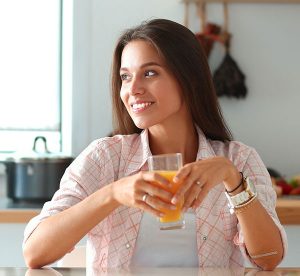 happy woman drinking carrot juice